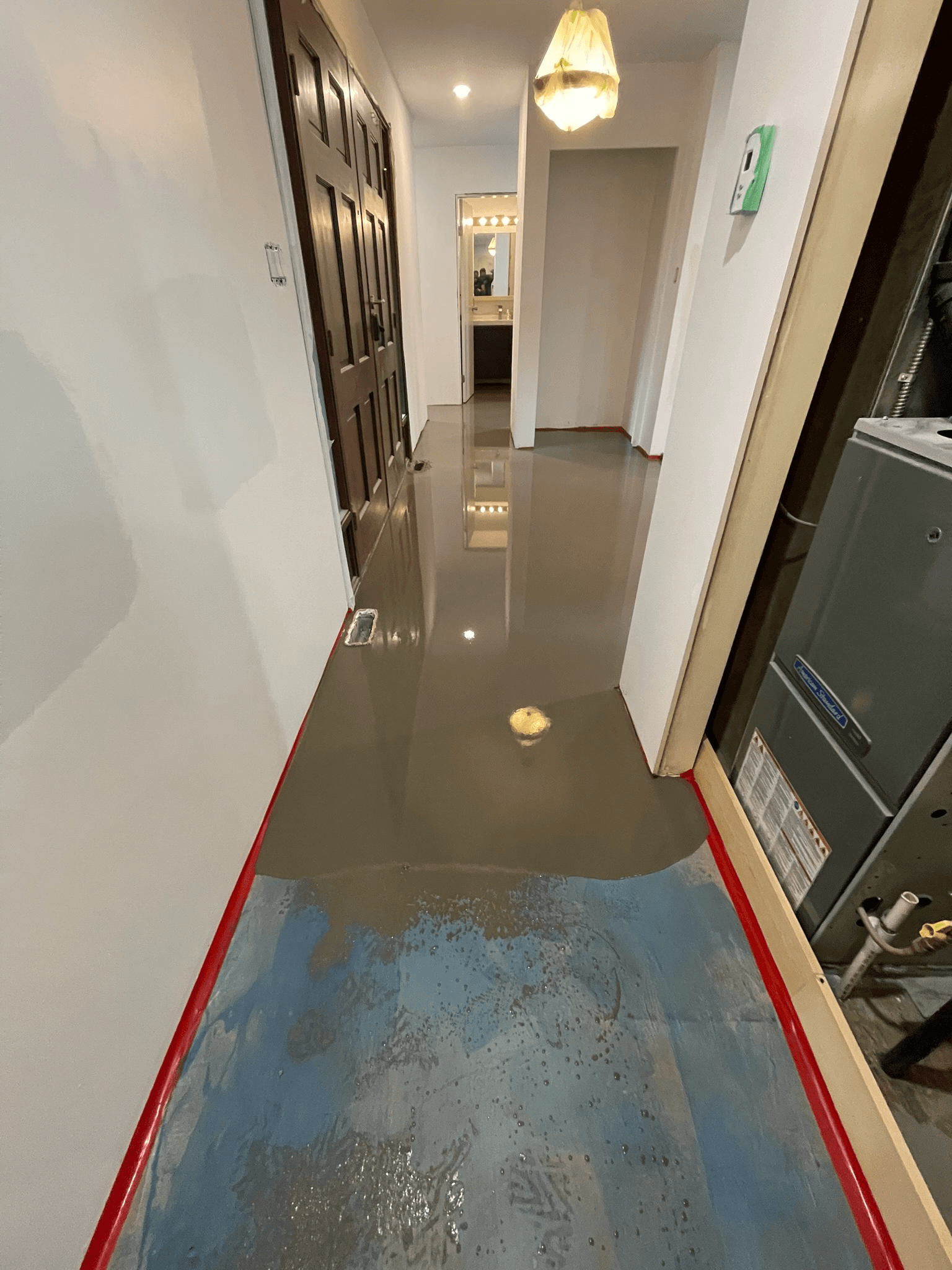 Fresh self-levelling underlayment poured through a hallway in a Delta home